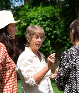 Grupo de personas conversando al aire libre en un ambiente relajado y soleado.