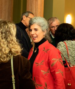 Mujer interactuando y conversando con otras personas en un evento social o networking.